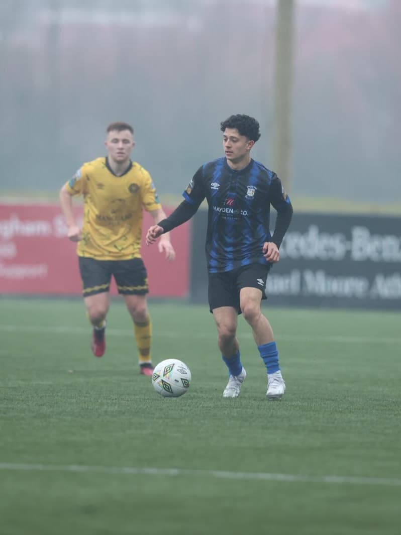 Coach Gabriel Padilla playing soccer in a blue and black kit.